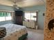 This light-blue main bedroom features two windows, dresser, ceiling fan and a TV at 417 Via Veneto, Venice, FL 34285