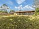 Expansive backyard features lush lawn, mature trees, and a screened-in porch at 4270 Ascot Dr, North Port, FL 34291