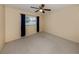 Bedroom featuring carpeted floors, a ceiling fan, and a window with blue curtains at 4270 Ascot Dr, North Port, FL 34291