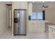 Bright kitchen featuring a stainless steel refrigerator and a breakfast bar area with white cabinetry at 4270 Ascot Dr, North Port, FL 34291
