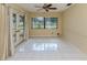 Bright living room with tile flooring, ceiling fan, large windows, and French doors to the exterior at 4270 Ascot Dr, North Port, FL 34291