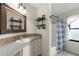 Bathroom with wood-framed mirror, vanity with drawers, shower and tile floors at 4305 Heyward St, North Port, FL 34291