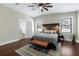 Bedroom with a unique headboard, dark wood floors, ceiling fan and lots of natural light at 4305 Heyward St, North Port, FL 34291