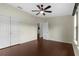 Bedroom with wood floors, ceiling fan, double door closet, and entrance into another room at 4305 Heyward St, North Port, FL 34291