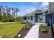 Inviting entryway showcasing a garden with a variety of small plants and gray sidewalk at 4305 Heyward St, North Port, FL 34291