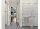 Hallway with gray flooring, white walls, and doors, leading to living room at 4305 Heyward St, North Port, FL 34291