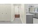 Hallway leading to a kitchen with gray cabinets and a living room with wood floors at 4305 Heyward St, North Port, FL 34291