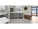 Bright kitchen features a gray tile floor, gray cabinets and stainless steel dishwasher at 4305 Heyward St, North Port, FL 34291