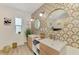 Bright bathroom boasts double vanity, round mirrors, stylish wallpaper, and natural light at 4321 Shamrock Dr, Venice, FL 34293