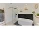 Modern bathroom featuring a soaking tub, glass-enclosed shower, and black and white tiling at 4321 Shamrock Dr, Venice, FL 34293