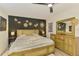 Bright bedroom featuring decorative wall art, fan, and a comfortable bed and dresser at 4321 Shamrock Dr, Venice, FL 34293