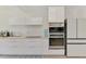 Modern kitchen featuring white cabinets, stainless steel appliances, and a view to the lush backyard at 4321 Shamrock Dr, Venice, FL 34293
