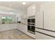 Modern kitchen featuring white cabinets, stainless steel appliances, and a view to the lush backyard at 4321 Shamrock Dr, Venice, FL 34293