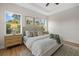 Well-lit main bedroom featuring two windows, neutral decor, tray ceiling, and en suite bathroom at 4390 Asteria Ter, North Port, FL 34287