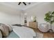 Bright main bedroom with tray ceiling, ceiling fan, and view into the living area at 4390 Asteria Ter, North Port, FL 34287