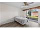 Cozy bedroom featuring a ceiling fan, sliding glass door to patio, and sleek, neutral décor at 458 Cerromar Rd # 382, Venice, FL 34293