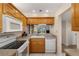 Well-lit kitchen features modern white appliances, wood cabinetry, and a mirrored backsplash at 458 Cerromar Rd # 382, Venice, FL 34293