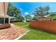 Backyard with brick patio, bench, green grass, wooden deck with outdoor seating at 4616 Leeta Ln, Sarasota, FL 34234