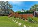 Backyard with green grass, wooden deck, and wooden privacy fence at 4616 Leeta Ln, Sarasota, FL 34234