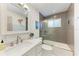 Bathroom with grey tile walls, glass shower door, white vanity and mirror at 4616 Leeta Ln, Sarasota, FL 34234