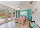 Bright bedroom with turquoise walls, hardwood floors, and pink French doors to the patio at 4616 Leeta Ln, Sarasota, FL 34234