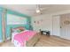 Brightly lit bedroom with hardwood floors, ceiling fan, and floral-themed decor at 4616 Leeta Ln, Sarasota, FL 34234