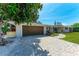 Inviting home exterior with a well-kept lawn, brick driveway, and a cozy front entrance with a pop of color at 4616 Leeta Ln, Sarasota, FL 34234