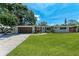 Charming single-story home featuring a manicured lawn, brick driveway, and a quaint front garden at 4616 Leeta Ln, Sarasota, FL 34234