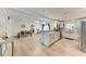 Open concept kitchen with an island, stainless appliances, view to dining area, and wood flooring at 4616 Leeta Ln, Sarasota, FL 34234
