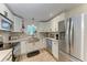 Well-lit kitchen featuring stainless steel appliances, granite countertops, and farmhouse sink at 4616 Leeta Ln, Sarasota, FL 34234
