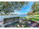 Picturesque park view featuring a peaceful bench, lush green grass, and waterfront homes in the distance under a sunny sky at 4616 Leeta Ln, Sarasota, FL 34234