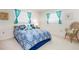 Cozy bedroom featuring blue bedding, a wicker chair, and natural light from windows at 465 Laurencin Dr, Nokomis, FL 34275
