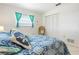 Bright bedroom with colorful bedding, a wicker chair, and a view of the closet at 465 Laurencin Dr, Nokomis, FL 34275