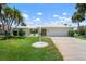 Landscaped front lawn with palms and meticulous shrubs with a 2 car garage at 465 Laurencin Dr, Nokomis, FL 34275