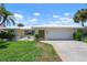 Charming single story home with a two car garage, well manicured shrubs, and vibrant green lawn at 465 Laurencin Dr, Nokomis, FL 34275