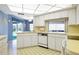 Bright kitchen with ample white cabinetry, unique overhead lighting, and a convenient pass-through window at 465 Laurencin Dr, Nokomis, FL 34275