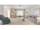 Bright living room with floral sofa and a glass coffee table with a ceiling fan at 465 Laurencin Dr, Nokomis, FL 34275