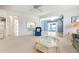 Open living space with blue armchair, view to the enclosed lanai, and pass-through kitchen at 465 Laurencin Dr, Nokomis, FL 34275