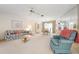 Bright, carpeted living room featuring a mirrored wall and ceiling fan at 465 Laurencin Dr, Nokomis, FL 34275