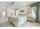 Bedroom with floral bedding, coordinating curtains, and neutral-toned furniture at 465 Laurencin Dr, Nokomis, FL 34275