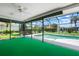 Screened-in pool area with green carpet, ceiling fan and view of backyard landscaping at 465 Laurencin Dr, Nokomis, FL 34275
