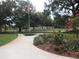 Peaceful community with lush greenery, a paved pathway, and an American flag at 512 W Venice Ave # 205, Venice, FL 34285