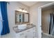 Bathroom with custom vanity, granite counters, decorative mirror, and a glass enclosed shower at 552 Bellaire Dr, Venice, FL 34293