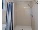 Bathroom with a shower featuring neutral tile and black and white shower curtain at 552 Bellaire Dr, Venice, FL 34293