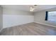 Bedroom with modern floors, ceiling fan, wainscotting, and window overlooking a yard at 552 Bellaire Dr, Venice, FL 34293