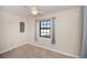 A bright bedroom features neutral carpet, a ceiling fan, and a window with curtains at 552 Bellaire Dr, Venice, FL 34293