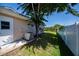 Exterior side yard featuring a well-maintained fence, lawn, mature tree, and AC unit at 552 Bellaire Dr, Venice, FL 34293