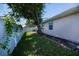 Fenced in side yard with an AC unit, mature tree and well maintained lawn, offering privacy at 552 Bellaire Dr, Venice, FL 34293