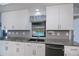 Modern kitchen features white cabinets, granite countertops, stainless steel appliances and a view of the pool at 552 Bellaire Dr, Venice, FL 34293