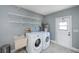 Bright laundry room features modern washer and dryer, utility sink, storage and access to outside at 552 Bellaire Dr, Venice, FL 34293